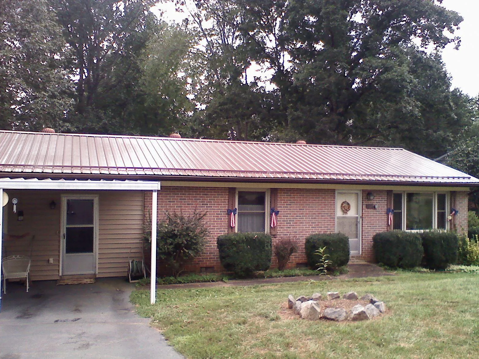Bronze metal roof and carport on a brick ranch home — Roof Repair work by our crew in Rural Hall