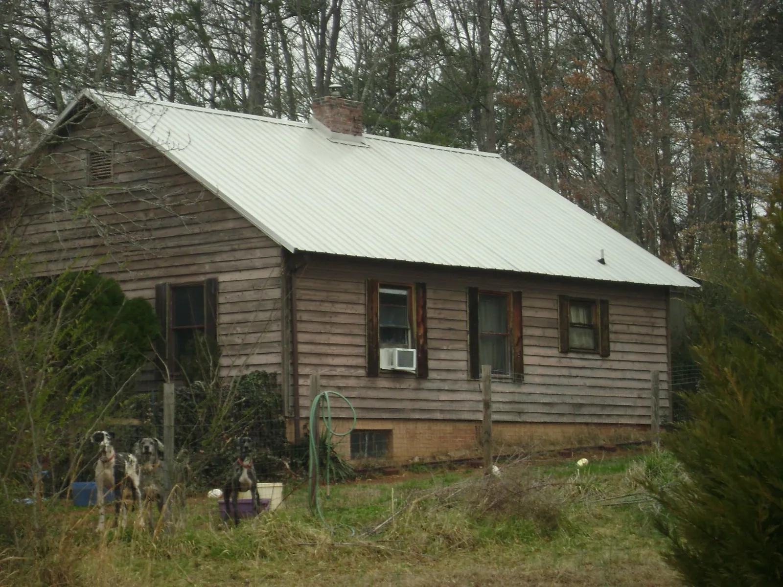 White metal roof on an old wood sided farmhouse, from a Metal Roof Installation job in Rural Hall